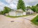 A detached one-car garage with white siding is on a gravel driveway with a neighboring home in the background at 2528 S Pennsylvania St, Indianapolis, IN 46225