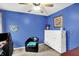 Bedroom with bright blue walls, ceiling fan, and white murphy bed and black accent chair at 2623 Senators Way, Indianapolis, IN 46217