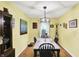 Bright dining room with wooden floors, complemented by a stylish light fixture and colorful wall art at 2623 Senators Way, Indianapolis, IN 46217