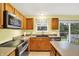 Cozy kitchen with wood cabinetry, stainless steel appliances, and a sliding glass door to the outdoor deck at 2623 Senators Way, Indianapolis, IN 46217