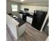 Modern kitchen with white cabinets, black countertops, and stainless-steel appliances at 2717 N Rural St, Indianapolis, IN 46218