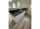 Kitchen island with stainless steel sink, white cabinets, granite countertops, and wood floors at 2717 N Rural St, Indianapolis, IN 46218