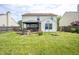 Large, grassy backyard with a wooden fence, patio, and a hot tub at 2730 Foxbriar Pl, Indianapolis, IN 46203
