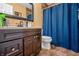 Bathroom with warm cabinets, a neutral counter, and a blue curtain over the shower/tub at 2730 Foxbriar Pl, Indianapolis, IN 46203