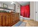 Cozy bathroom featuring a wood vanity, dark fixtures, and a red curtain over the shower at 2730 Foxbriar Pl, Indianapolis, IN 46203