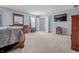 Bright bedroom featuring neutral walls, carpet, and a bed with warm wood furniture at 2730 Foxbriar Pl, Indianapolis, IN 46203