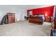 Large bedroom with a red accent wall, a dark wood bedroom set, and light carpet at 2730 Foxbriar Pl, Indianapolis, IN 46203