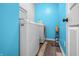 Bright laundry room with blue walls and dark vinyl flooring, featuring a modern washer and dryer at 2730 Foxbriar Pl, Indianapolis, IN 46203