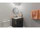 Stylish powder room with shiplap walls, a modern vanity, a round mirror, and decorative towels at 2953 Foxborough Dr, Greenwood, IN 46143