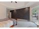 Spacious main bedroom showcasing a geometric accent wall and access to an outdoor deck at 2953 Foxborough Dr, Greenwood, IN 46143
