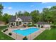 Back of home with a large in-ground pool surrounded by a patio and lush greenery, perfect for entertaining at 2953 Foxborough Dr, Greenwood, IN 46143