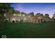 A spacious backyard featuring a well-maintained lawn, a charming two-story house, and a delightful playhouse with a slide at 2971 N Buck Creek Rd, Greenfield, IN 46140