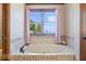 A soaking tub is encased with decorative tile below a window with purple curtains at 2971 N Buck Creek Rd, Greenfield, IN 46140