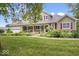 Beautiful home showcasing a manicured lawn, welcoming porch, and attached garage at 2971 N Buck Creek Rd, Greenfield, IN 46140