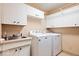 Functional laundry room featuring white cabinets and modern washer and dryer units at 2971 N Buck Creek Rd, Greenfield, IN 46140