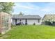 Spacious backyard featuring a greenhouse, grassy area, and mature trees at 305 W Vinyard St, Anderson, IN 46011