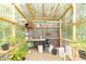 Well-organized greenhouse interior with plants, shelving, and natural light at 305 W Vinyard St, Anderson, IN 46011