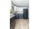 Modern kitchen features white upper cabinets, gray lower cabinets, stainless steel appliances, subway tile backsplash, and wood grain flooring at 305 W Vinyard St, Anderson, IN 46011