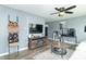 Cozy living room with a ceiling fan, television, wood flooring, and unique decor at 305 W Vinyard St, Anderson, IN 46011