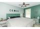 A spacious main bedroom with calming paint and a ceiling fan above a comfy bed at 305 W Vinyard St, Anderson, IN 46011
