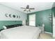 A spacious main bedroom with calming paint and a ceiling fan above a comfy bed at 305 W Vinyard St, Anderson, IN 46011