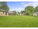 Expansive green backyard with multiple outbuildings and lush trees at 3526 Westfield Dr, Anderson, IN 46011