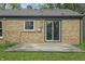 View of the home exterior with sliding glass door and brick wall, showcasing the back patio area and design at 3526 Westfield Dr, Anderson, IN 46011
