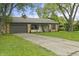 Charming brick home with an attached garage, a well-manicured lawn and tree lined driveway at 3526 Westfield Dr, Anderson, IN 46011