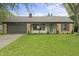 Charming brick home with a well-manicured lawn, attached garage and inviting front porch with hanging flower baskets at 3526 Westfield Dr, Anderson, IN 46011
