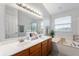 Bright bathroom featuring a double vanity, large mirror, and soaking tub at 3638 Fieldstone Ln, Plainfield, IN 46168