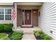 Charming front porch with an American flag, a decorative wreath on the front door, and landscaped flower beds at 3638 Fieldstone Ln, Plainfield, IN 46168