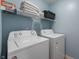Bright laundry room includes a washer, dryer and shelf storage for linens and cleaning supplies at 3638 Fieldstone Ln, Plainfield, IN 46168