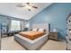 This is a staged main bedroom with a tray ceiling, a nice sized window, and calming blue walls at 3638 Fieldstone Ln, Plainfield, IN 46168