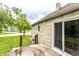 Well-maintained home backyard featuring a glass sliding door, landscaped lawn, and nearby trees at 4435 E 38Th St, Indianapolis, IN 46218