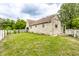 Spacious home backyard with green lawn, white picket fence, and classic stone house at 4435 E 38Th St, Indianapolis, IN 46218