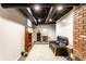 Finished basement showcasing a gray sofa, decorative shelving, and exposed black pipes at 4435 E 38Th St, Indianapolis, IN 46218