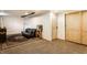 Cozy finished basement with a gray futon, textured rug, and adjacent blonde wood cabinets at 4435 E 38Th St, Indianapolis, IN 46218
