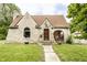 Charming stone home featuring a covered porch, arched window and a well-manicured lawn at 4435 E 38Th St, Indianapolis, IN 46218