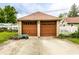 Spacious two car garage featuring wooden doors and a paved driveway at 4435 E 38Th St, Indianapolis, IN 46218