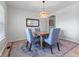 Bright dining room featuring a modern chandelier, wood table, blue upholstered chairs, and accent rug at 4681 Shelby Cir, Greenwood, IN 46143