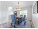 Dining room featuring a modern chandelier, wood table, blue upholstered chairs, and accent rug at 4681 Shelby Cir, Greenwood, IN 46143