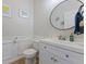Cozy powder room featuring a modern round mirror, white wainscoting, and stylish fixtures at 4681 Shelby Cir, Greenwood, IN 46143