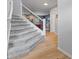 A home staircase with soft gray carpet, leading into a bright living area with wood flooring at 4681 Shelby Cir, Greenwood, IN 46143