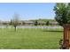 Backyard view of green grass, a lake, fence, and several houses, perfect for outdoor activities and entertaining at 5101 W Bay Rd, Plainfield, IN 46168