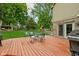 Wide wooden deck with outdoor furniture overlooks a large lawn and play set at 5412 Green Hills Dr, Brownsburg, IN 46112