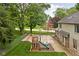 Backyard featuring a basketball court and a play structure, fenced in and surrounded by mature trees at 5412 Green Hills Dr, Brownsburg, IN 46112