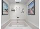 Relaxing bathroom featuring a large soaking tub with beach themed décor and art at 5412 Green Hills Dr, Brownsburg, IN 46112
