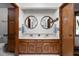 Bathroom with a wood vanity, double sinks, round mirrors, and white walls at 5412 Green Hills Dr, Brownsburg, IN 46112