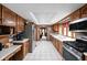 Long kitchen layout boasts stainless steel appliances, wood cabinets, and tiled floors for a bright, clean space at 5412 Green Hills Dr, Brownsburg, IN 46112