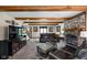 Comfortable living room features a brick fireplace, beamed ceilings, and plush leather seating for a cozy ambiance at 5412 Green Hills Dr, Brownsburg, IN 46112